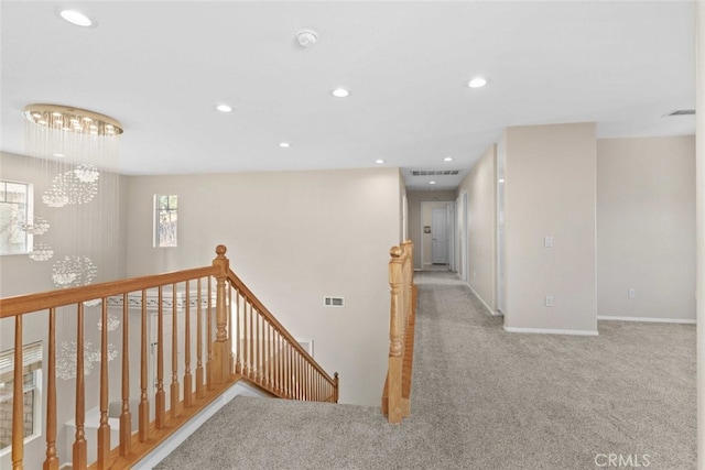 hall featuring a chandelier and light carpet