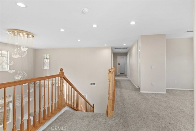 hall featuring carpet, recessed lighting, visible vents, an upstairs landing, and a chandelier