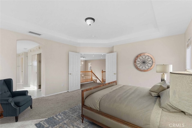 bedroom featuring carpet floors and a raised ceiling