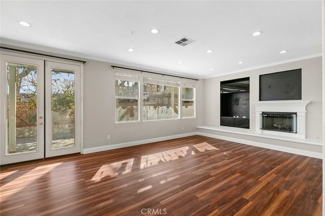 unfurnished living room featuring hardwood / wood-style flooring, ornamental molding, and french doors