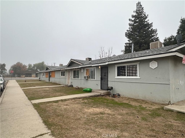 ranch-style house featuring a front yard and central air condition unit