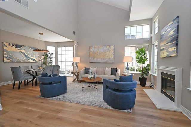 living room featuring hardwood / wood-style flooring and a towering ceiling