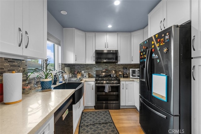 kitchen featuring light stone countertops, white cabinetry, and appliances with stainless steel finishes