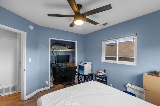 bedroom featuring ceiling fan, dark hardwood / wood-style floors, and a closet