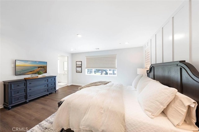 bedroom with connected bathroom and dark hardwood / wood-style floors