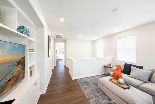 living room featuring plenty of natural light and dark hardwood / wood-style flooring