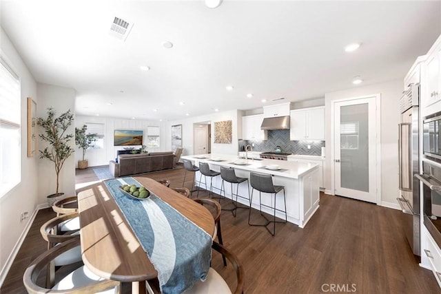 dining area featuring sink, a wealth of natural light, and dark hardwood / wood-style floors