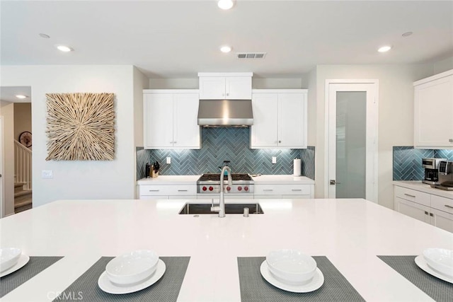 kitchen featuring tasteful backsplash, white cabinetry, and sink