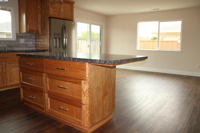 kitchen featuring dark hardwood / wood-style floors, tasteful backsplash, sink, a breakfast bar area, and stainless steel refrigerator with ice dispenser