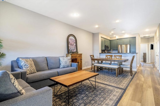 living room with sink and light hardwood / wood-style flooring