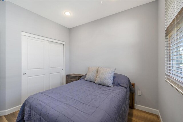 bedroom featuring hardwood / wood-style floors and a closet