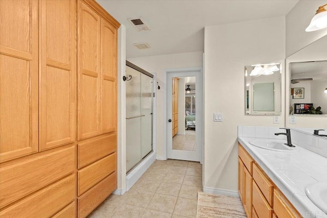 ensuite bathroom with visible vents, connected bathroom, a stall shower, and a sink