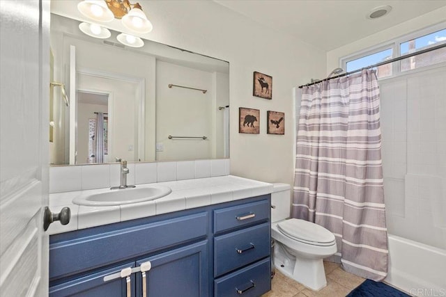 full bath featuring tile patterned floors, shower / bath combo with shower curtain, toilet, and vanity