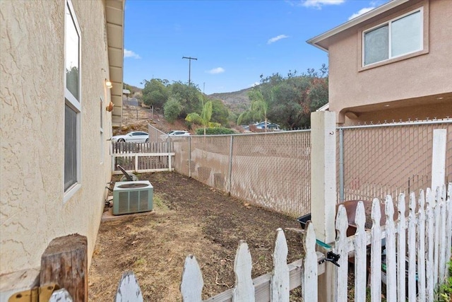 view of yard with central air condition unit and a fenced backyard