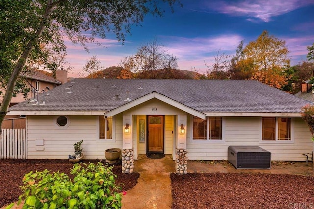 ranch-style house with roof with shingles and a chimney