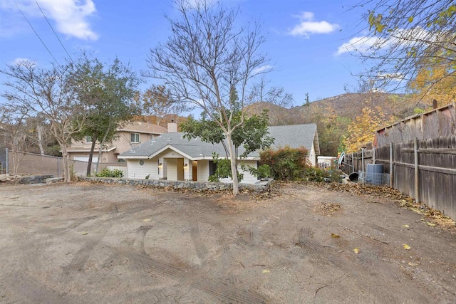 view of front of house featuring fence, a mountain view, and a chimney