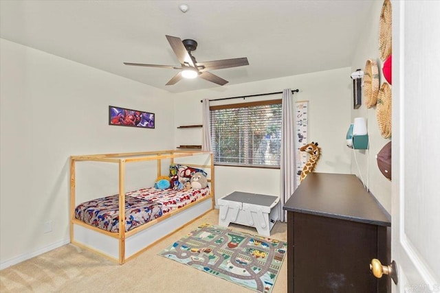 carpeted bedroom featuring baseboards and a ceiling fan