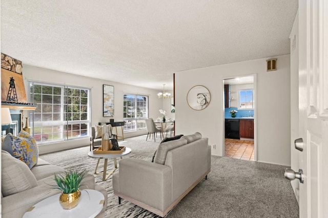 living room featuring an inviting chandelier, carpet floors, and a textured ceiling