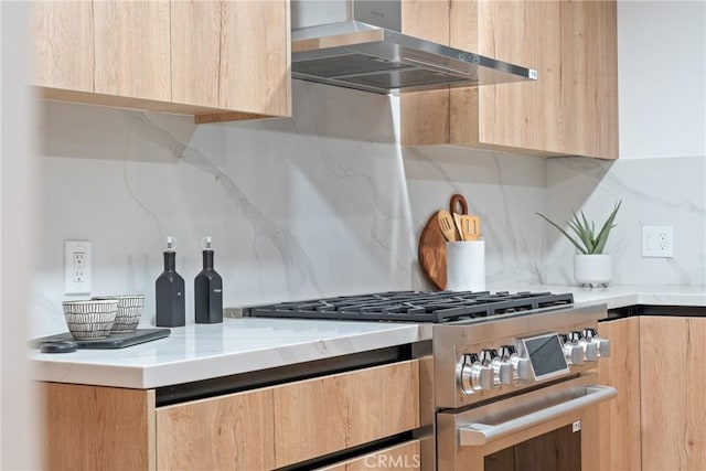 kitchen with high end stainless steel range oven, modern cabinets, exhaust hood, and light brown cabinetry