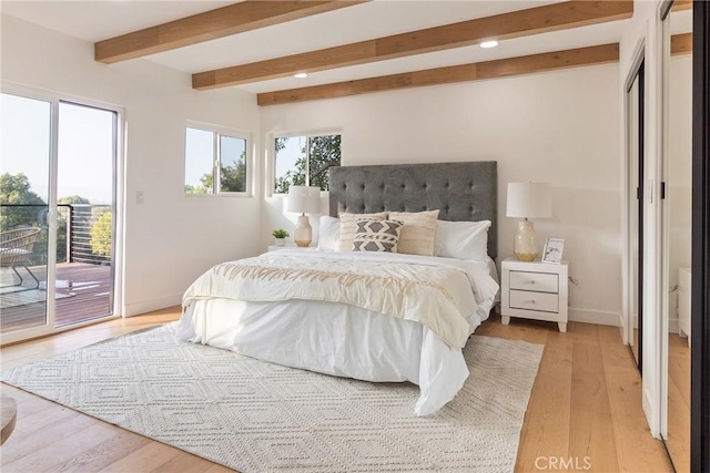 bedroom featuring baseboards, light wood-style floors, beam ceiling, and access to exterior