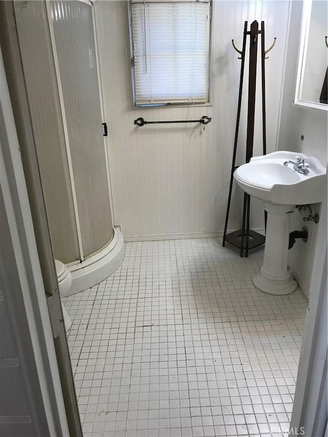 bathroom featuring tile patterned floors, toilet, and walk in shower