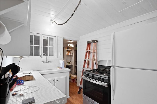 1149 Apple Ave, Wrightwood, CA 92397 - kitchen featuring light countertops, gas stove, a sink, light wood-style floors, and freestanding refrigerator