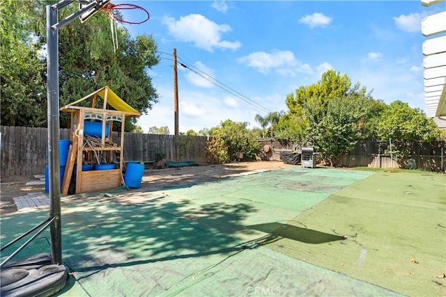 view of basketball court with a playground