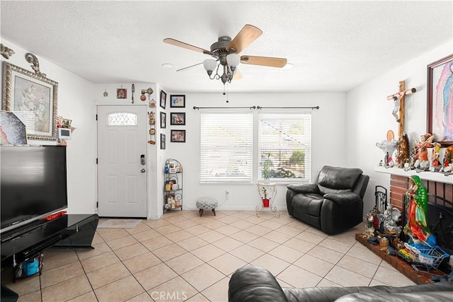 living room featuring ceiling fan, a textured ceiling, and light tile patterned flooring