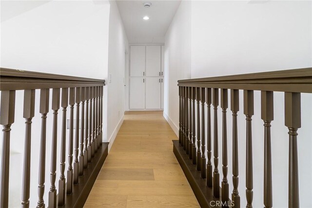 hall with recessed lighting, light wood-style floors, and baseboards