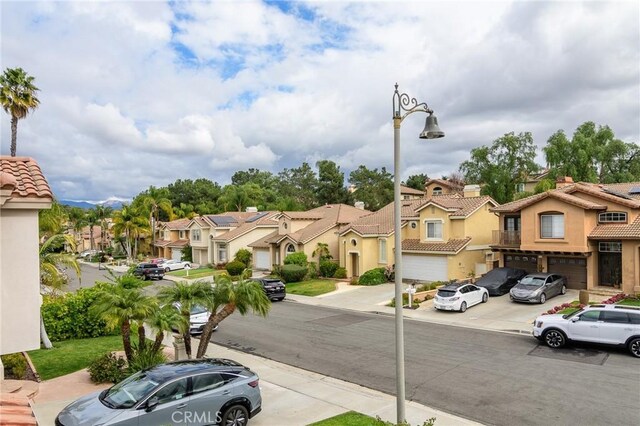 view of road featuring a residential view, curbs, street lights, and sidewalks