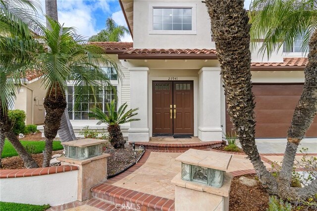 property entrance featuring a tile roof and stucco siding