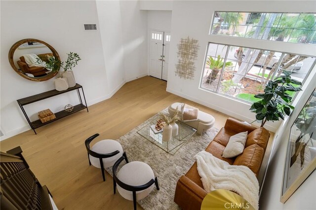 living room featuring visible vents, baseboards, and wood finished floors