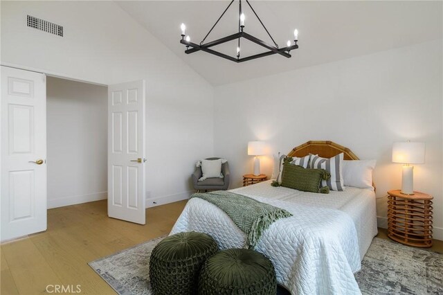 bedroom with visible vents, high vaulted ceiling, a notable chandelier, light wood-style floors, and baseboards