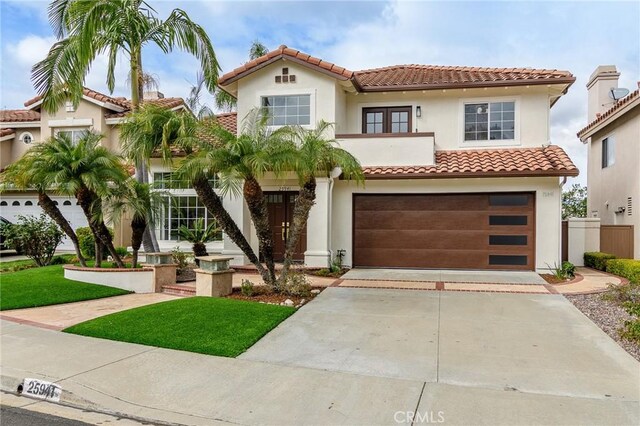 mediterranean / spanish-style house featuring stucco siding, a garage, driveway, and a tile roof