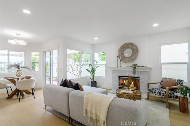 living room with recessed lighting, baseboards, light wood-style floors, and a fireplace