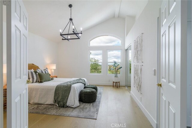 bedroom with light wood-type flooring, beamed ceiling, high vaulted ceiling, an inviting chandelier, and baseboards