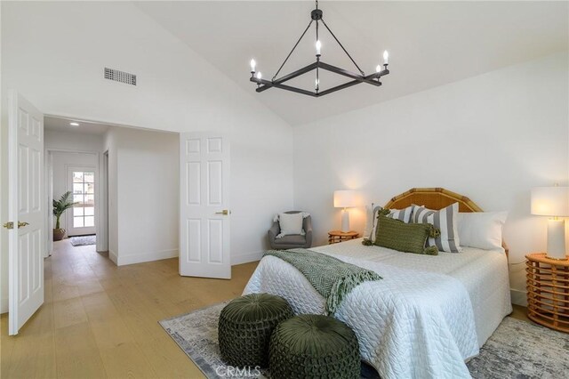 bedroom with light wood-type flooring, visible vents, high vaulted ceiling, a notable chandelier, and baseboards