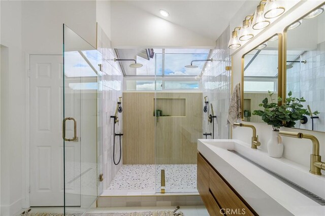 bathroom featuring a stall shower, vanity, and vaulted ceiling