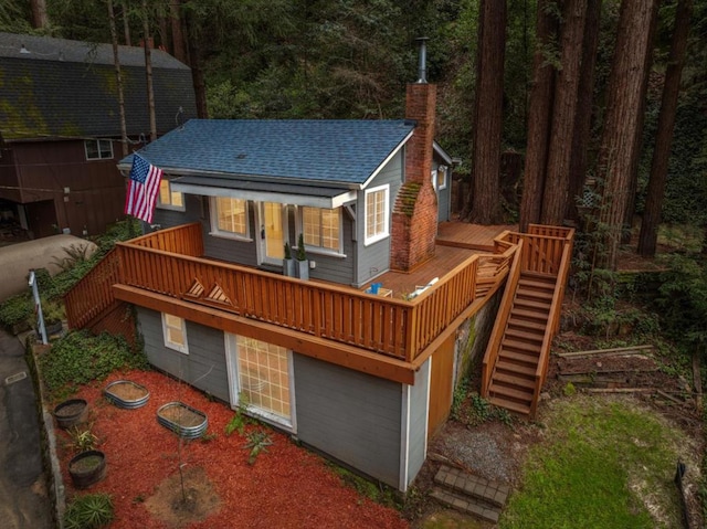 rear view of house with a wooden deck and a garage