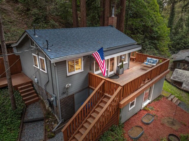 rear view of property featuring an outdoor living space and a wooden deck