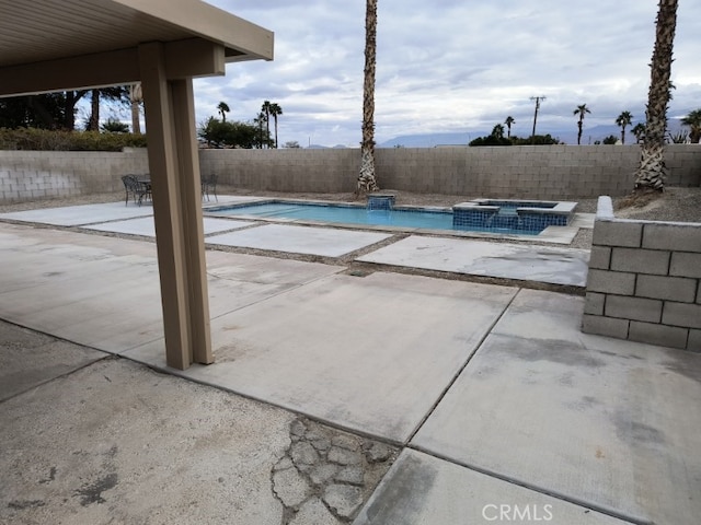 view of swimming pool with a patio and an in ground hot tub