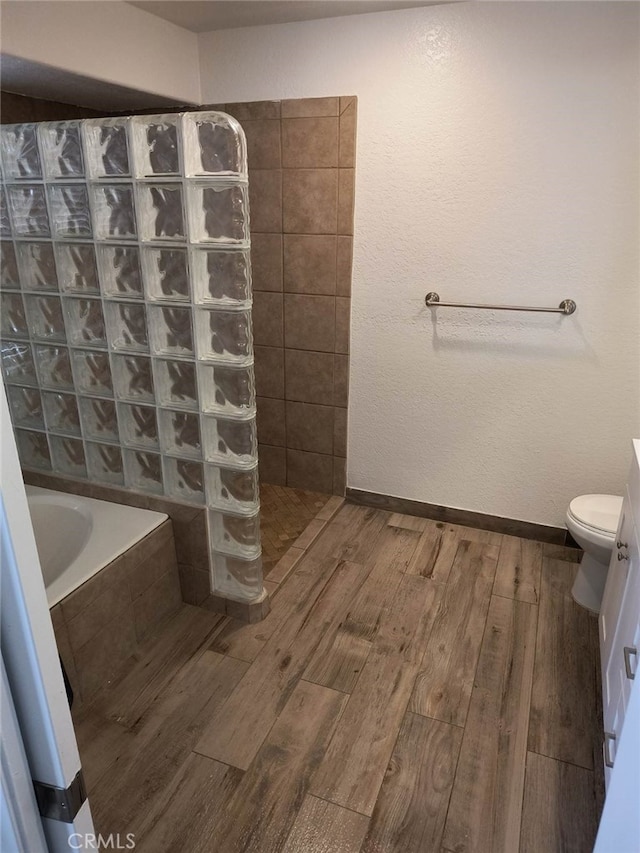 bathroom with tiled shower and toilet