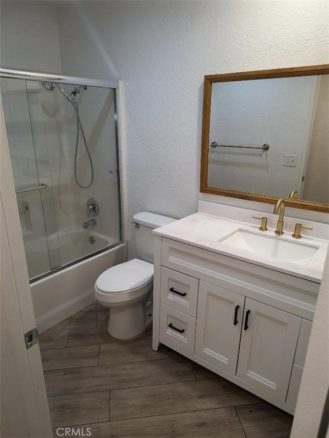 full bathroom with vanity, combined bath / shower with glass door, and toilet