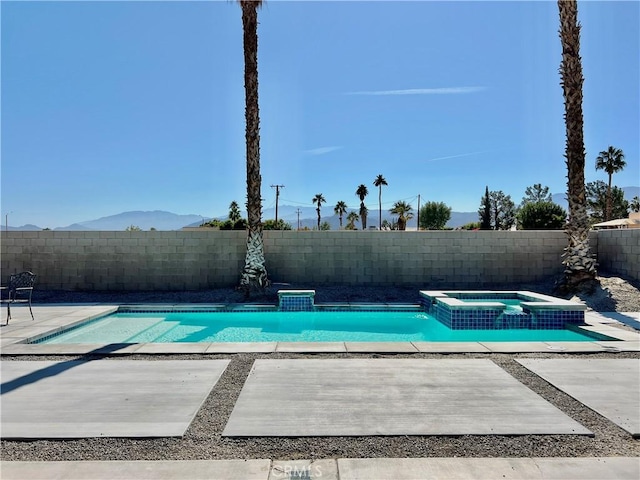 view of swimming pool featuring an in ground hot tub and a mountain view