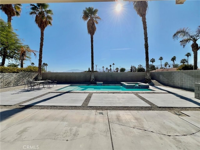 view of swimming pool featuring an in ground hot tub and a patio area