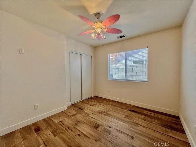 unfurnished bedroom with ceiling fan, a closet, and light hardwood / wood-style flooring