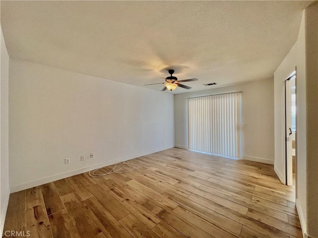 empty room featuring ceiling fan, a textured ceiling, and light hardwood / wood-style floors