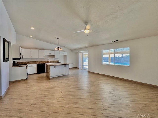 kitchen featuring white cabinetry, a center island, hanging light fixtures, light hardwood / wood-style floors, and ceiling fan with notable chandelier