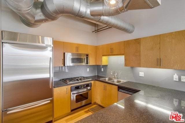 kitchen featuring appliances with stainless steel finishes, sink, and decorative backsplash