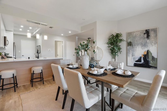 dining room featuring sink and light hardwood / wood-style floors